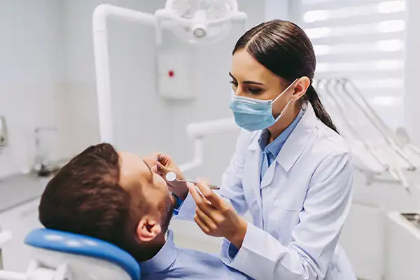 Dentist examining a patient's teeth Dentist examining a patient's teeth